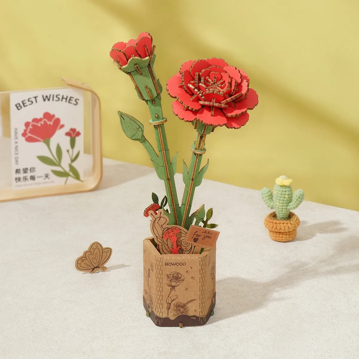 Rowood Red Carnation TW052 DIY wooden flower in decorative pot with red carnation bloom and bud on a warm lifestyle background.