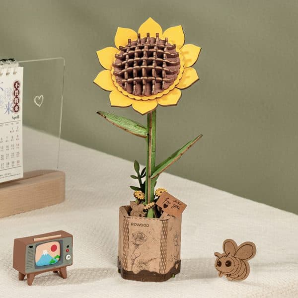 Rowood Sunflower TW011 wooden flower displayed on a desk with miniature accessories