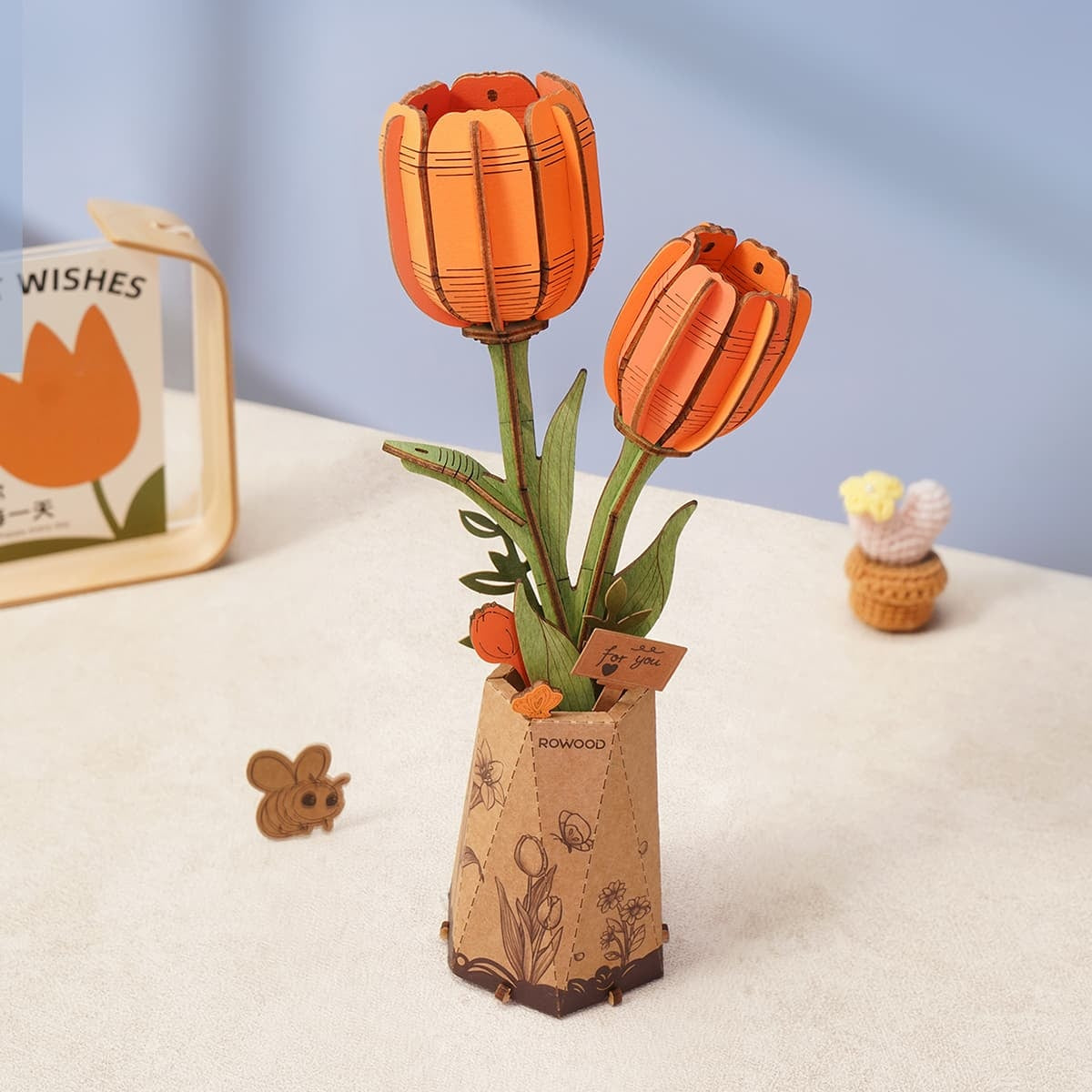 Rowood Orange Tulip TW081 DIY wooden flower displayed in a warm lifestyle scene with two orange tulip blooms and decorative paper pot.