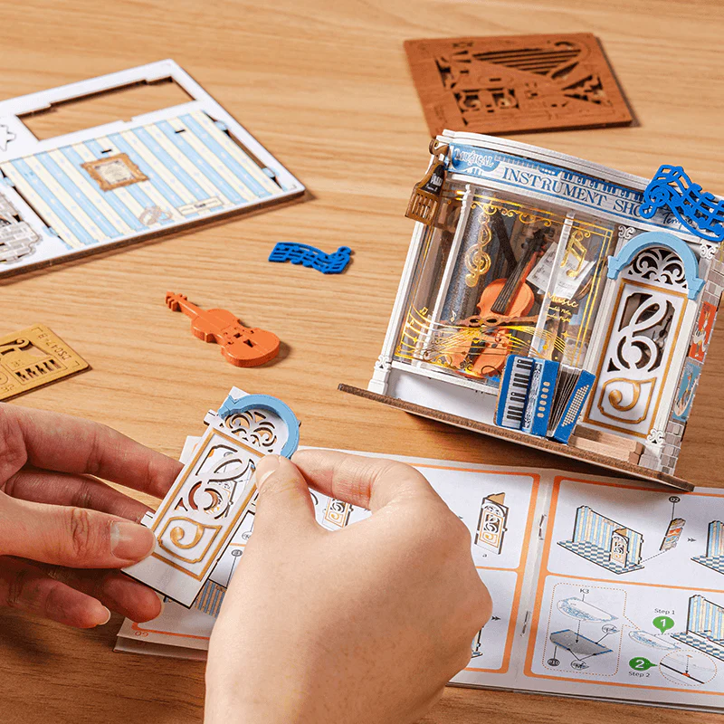 Hands assembling Rolife Melody Instrument Shop DS047 DIY miniature house kit with instruction manual